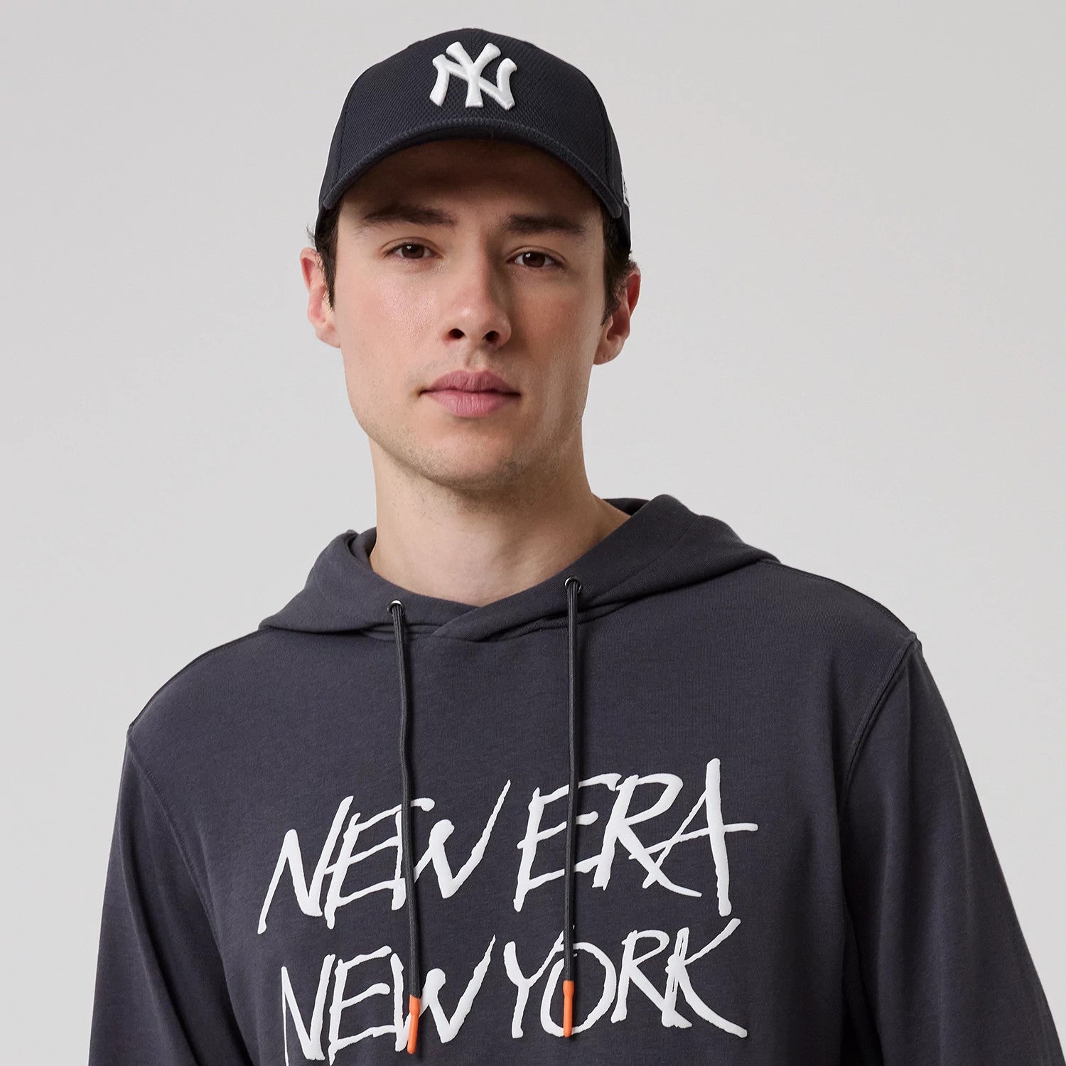 The model is wearing this New Era New York Oversized Pullover Hoodie in dark grey. 6