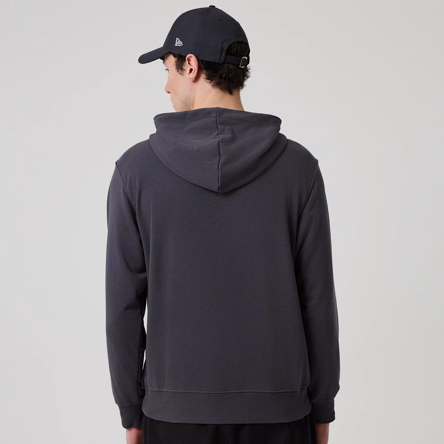 The model is wearing this New Era New York Oversized Pullover Hoodie in dark grey. 2