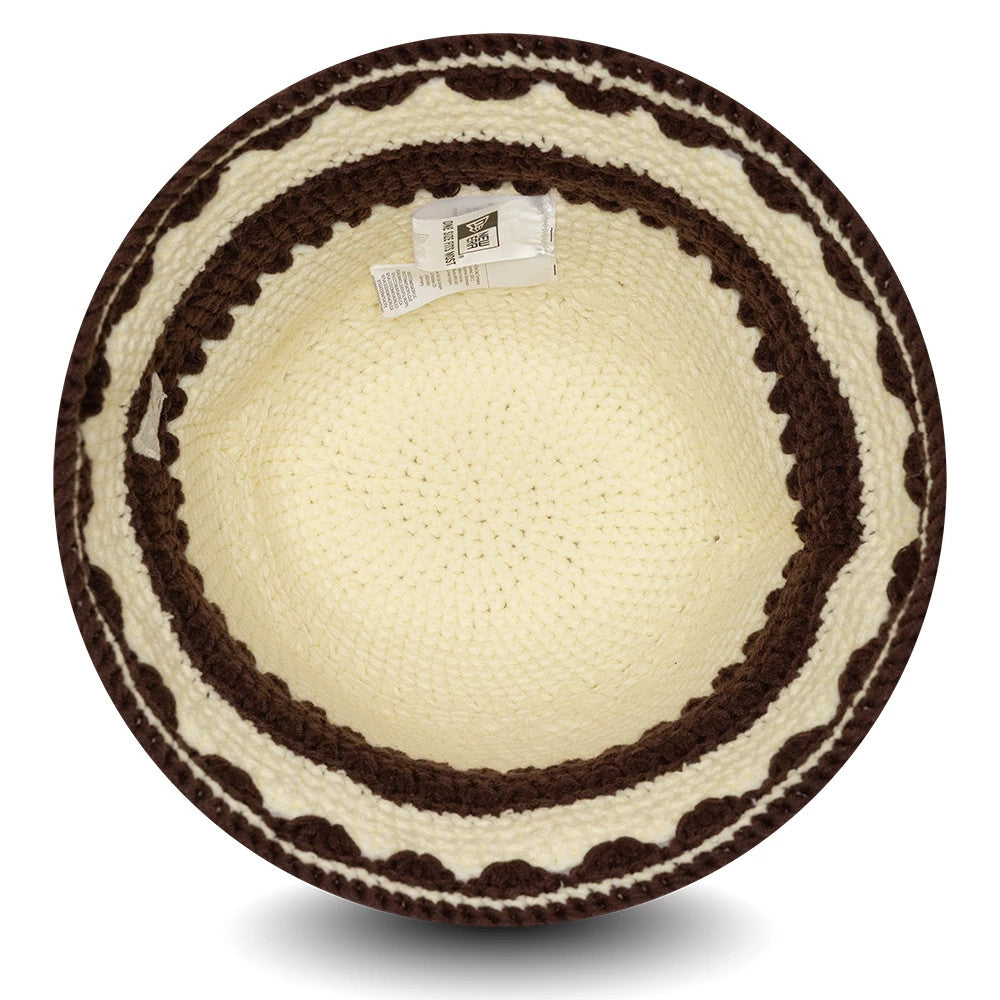 New Era Crochet Border White Explorer Bucket Hat, inside view showing the intricate beige crochet pattern on the crown and a brown scalloped border around the brim, with a white care label attached inside.