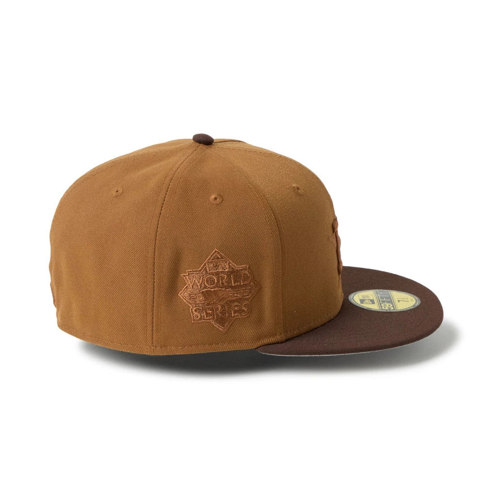 Houston Astros MLB Brown New Era 59FIFTY Fitted Cap, three-quarter view showing the brown embroidered World Series logo on the right panel and a brown visor with a gold 59FIFTY size sticker on top.