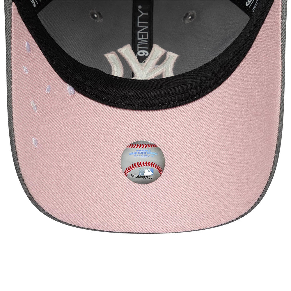 New York Yankees MLB Sakura Nagashi Grey New Era 9TWENTY Adjustable Cap, inside view showing the grey undervisor with a baseball-themed sticker centred, contrasted by pink stitching details and black taping.