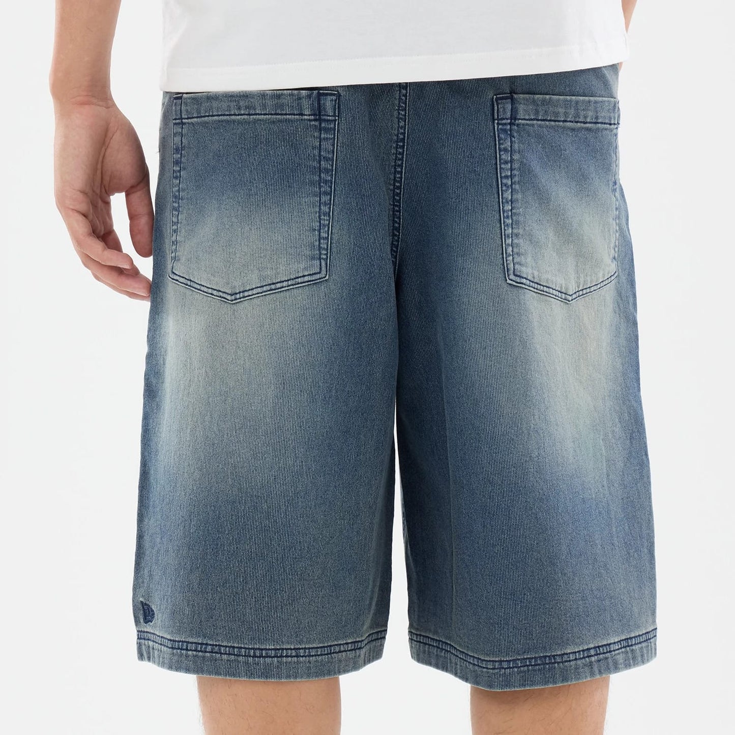 The model is wearing this New Era Washed Bermuda Shorts in blue. 5