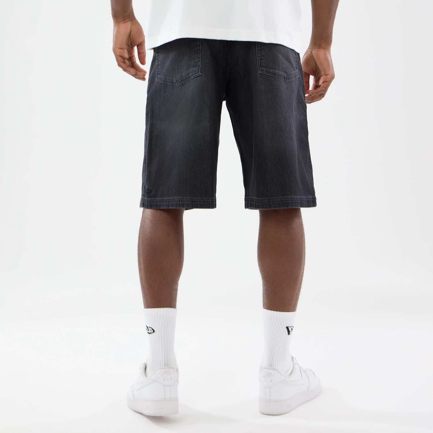 The model is wearing this New Era Washed Bermuda Shorts in black. 2