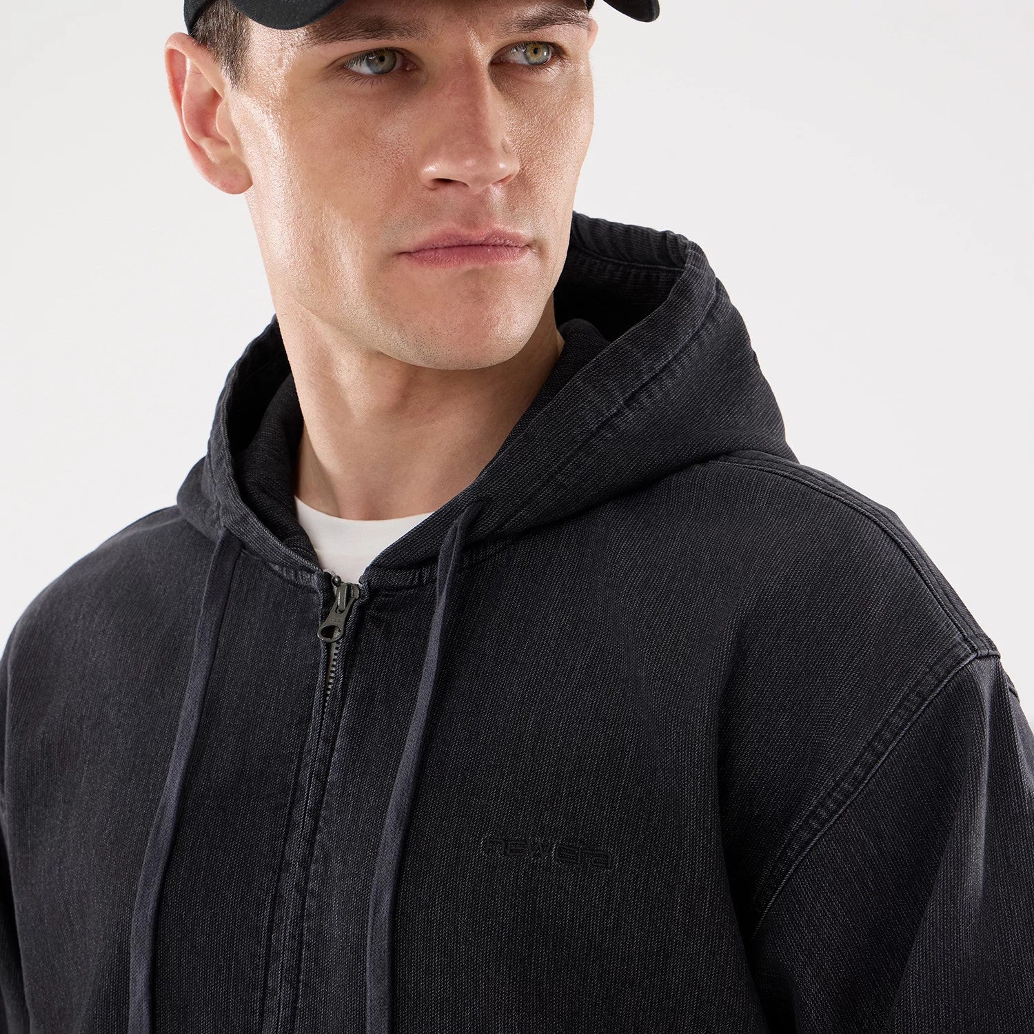 The model is wearing this New Era Washed Full Zip Hoodie in black. 4