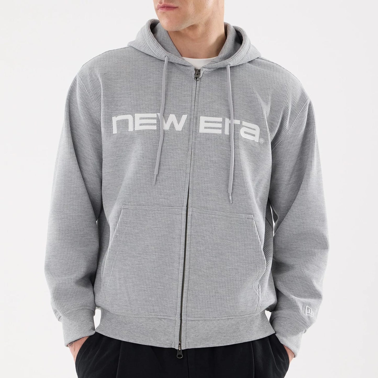 The model is wearing this New Era Waffle Full Zip Hoodie in grey. 3