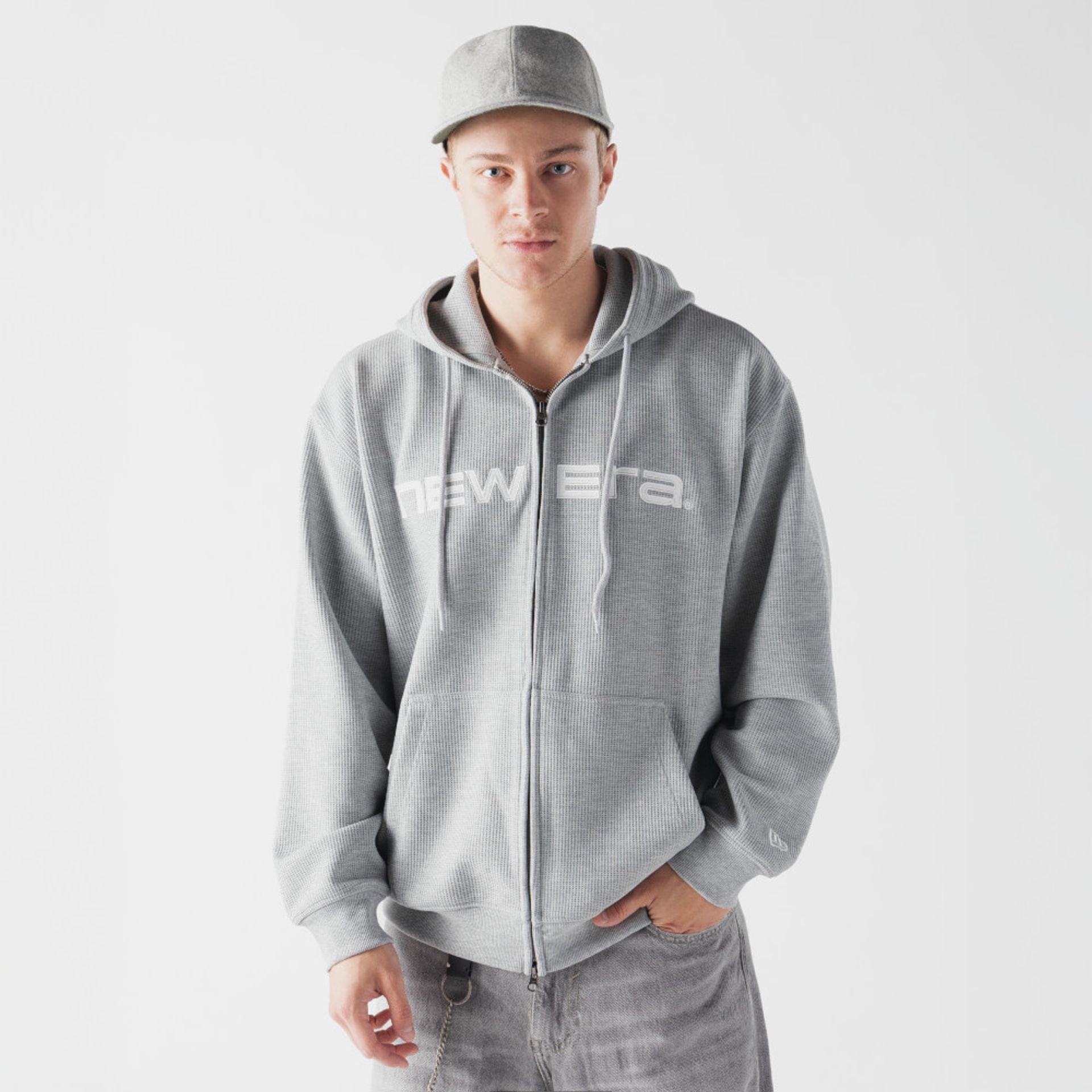 The model is wearing this New Era Waffle Full Zip Hoodie in grey. 1