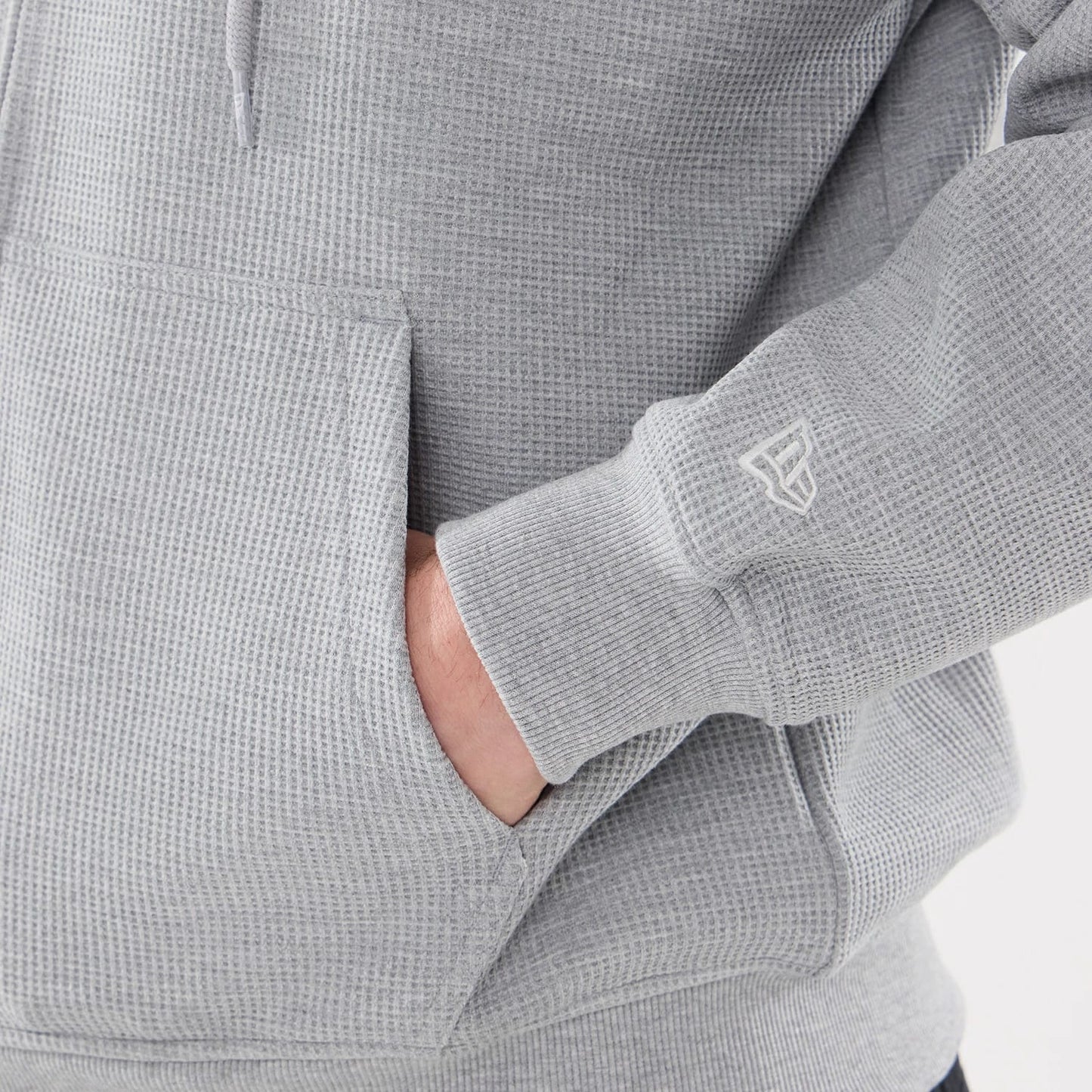 The model is wearing this New Era Waffle Full Zip Hoodie in grey. 5