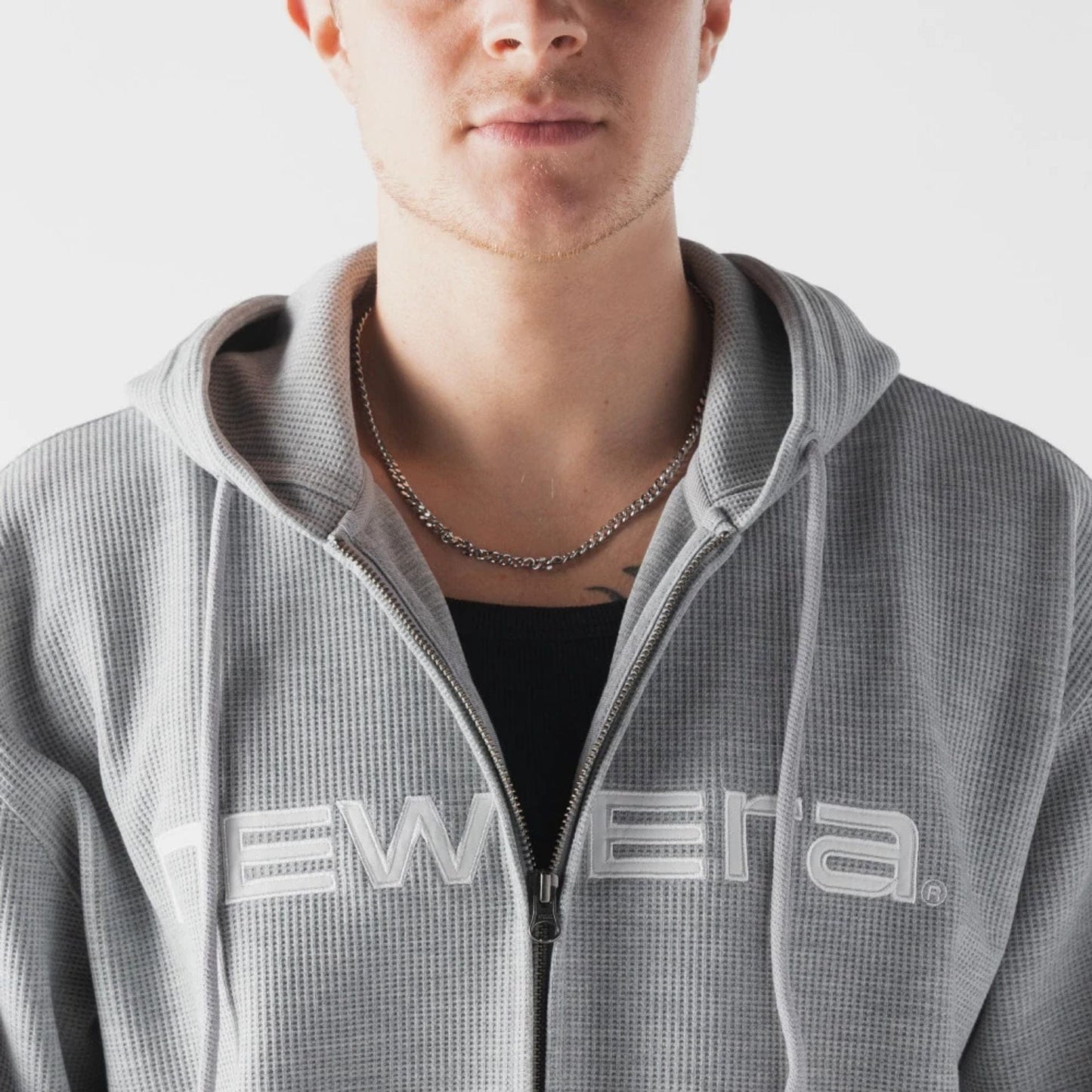 The model is wearing this New Era Waffle Full Zip Hoodie in grey. 3