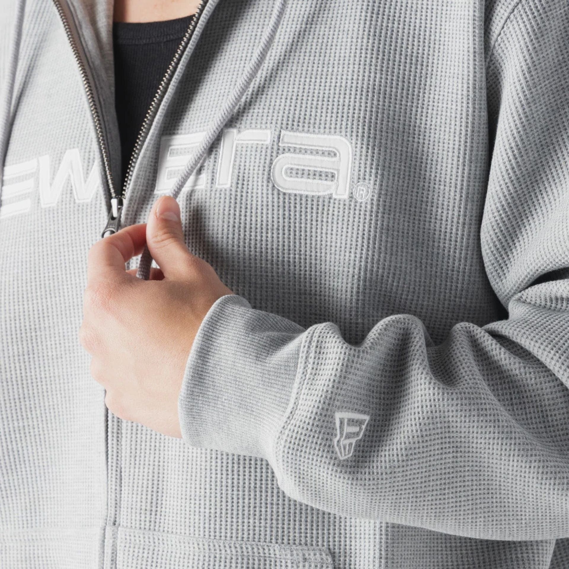 The model is wearing this New Era Waffle Full Zip Hoodie in grey. 4
