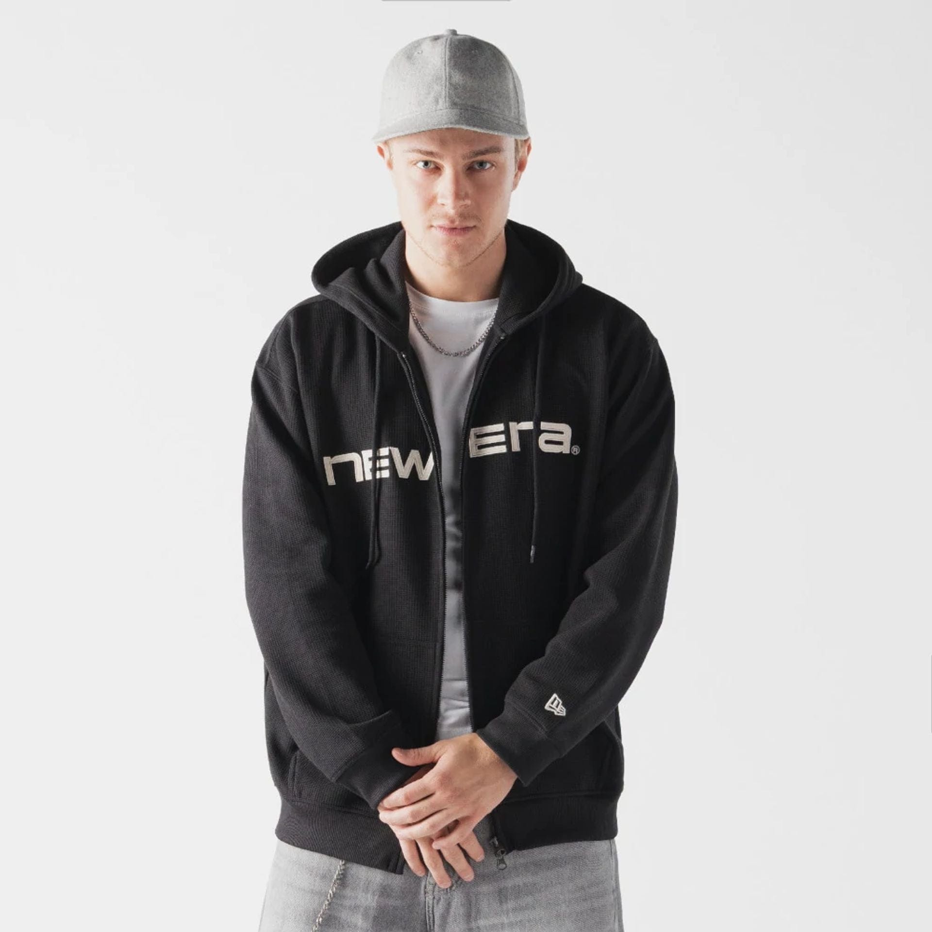 The model is wearing this New Era Waffle Full Zip Hoodie in black. 1
