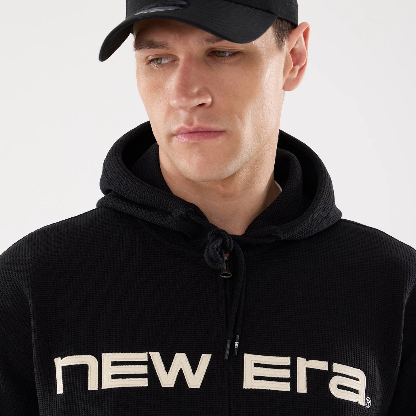 The model is wearing this New Era Waffle Full Zip Hoodie in black. 3