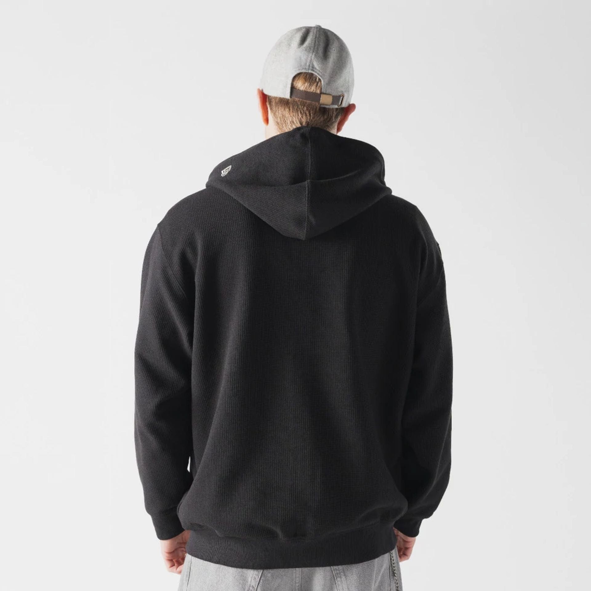 The model is wearing this New Era Waffle Full Zip Hoodie in black. 2
