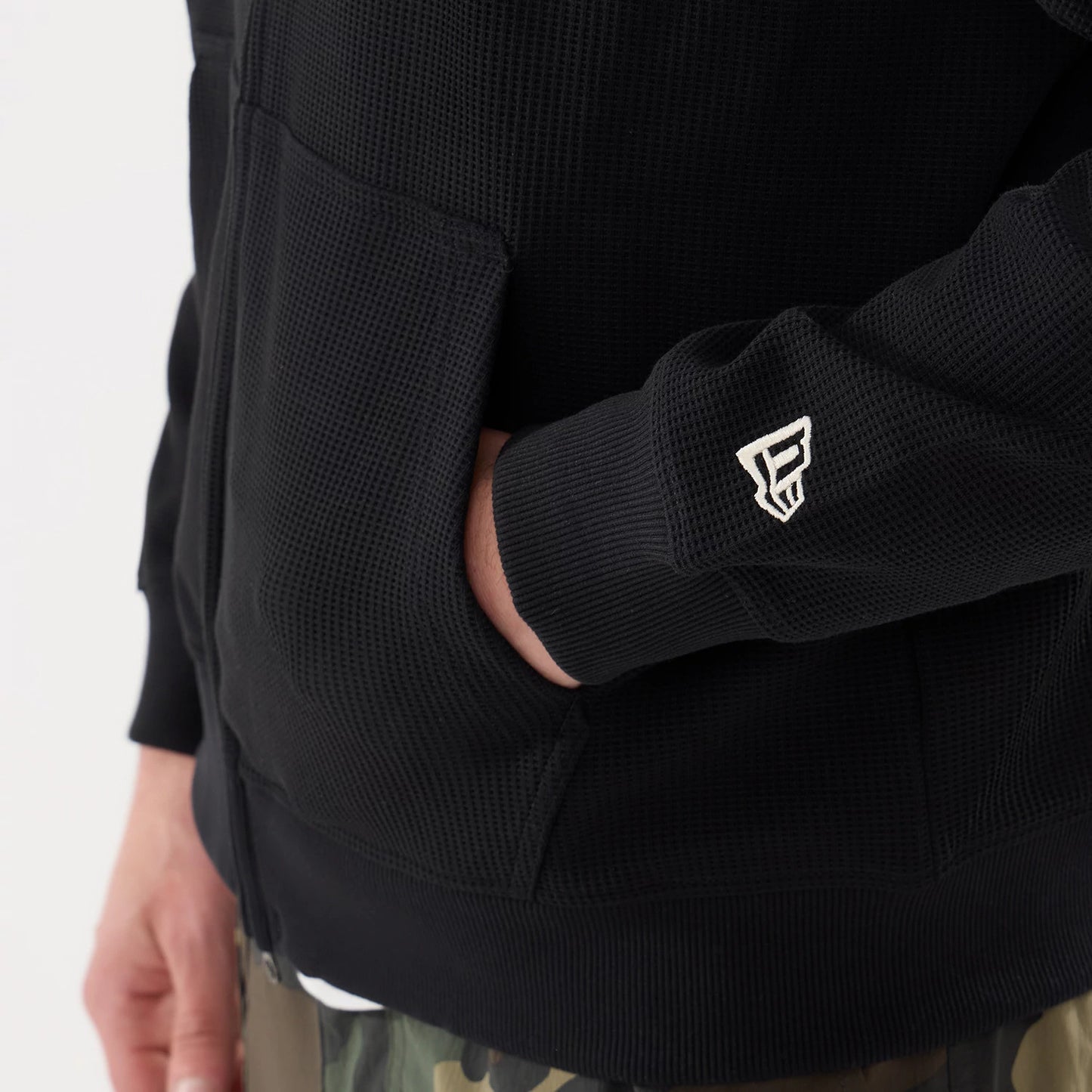 The model is wearing this New Era Waffle Full Zip Hoodie in black. 5