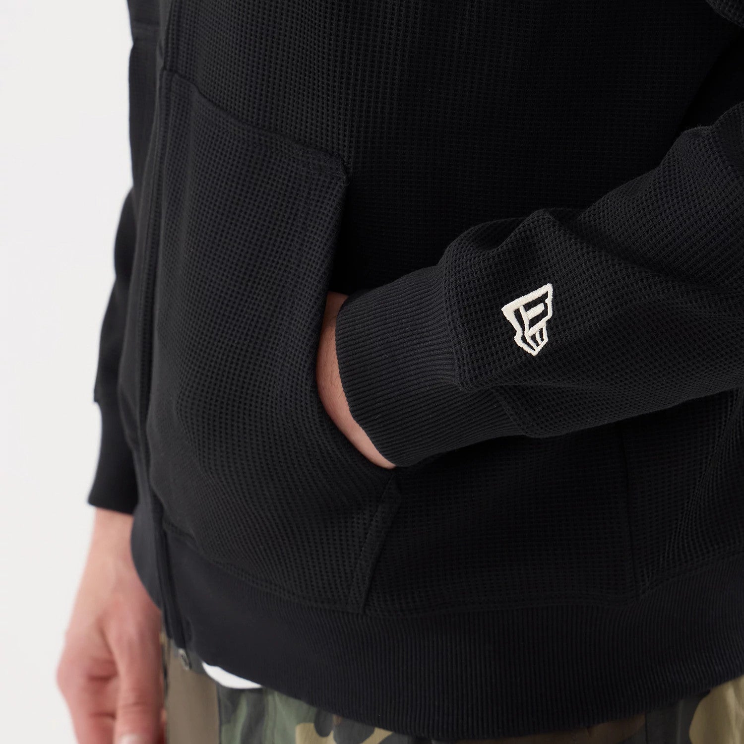 The model is wearing this New Era Waffle Full Zip Hoodie in black. 5