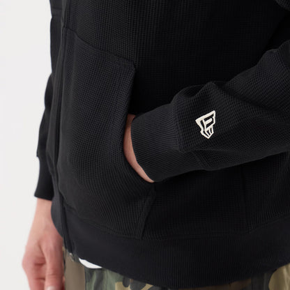 The model is wearing this New Era Waffle Full Zip Hoodie in black. 5