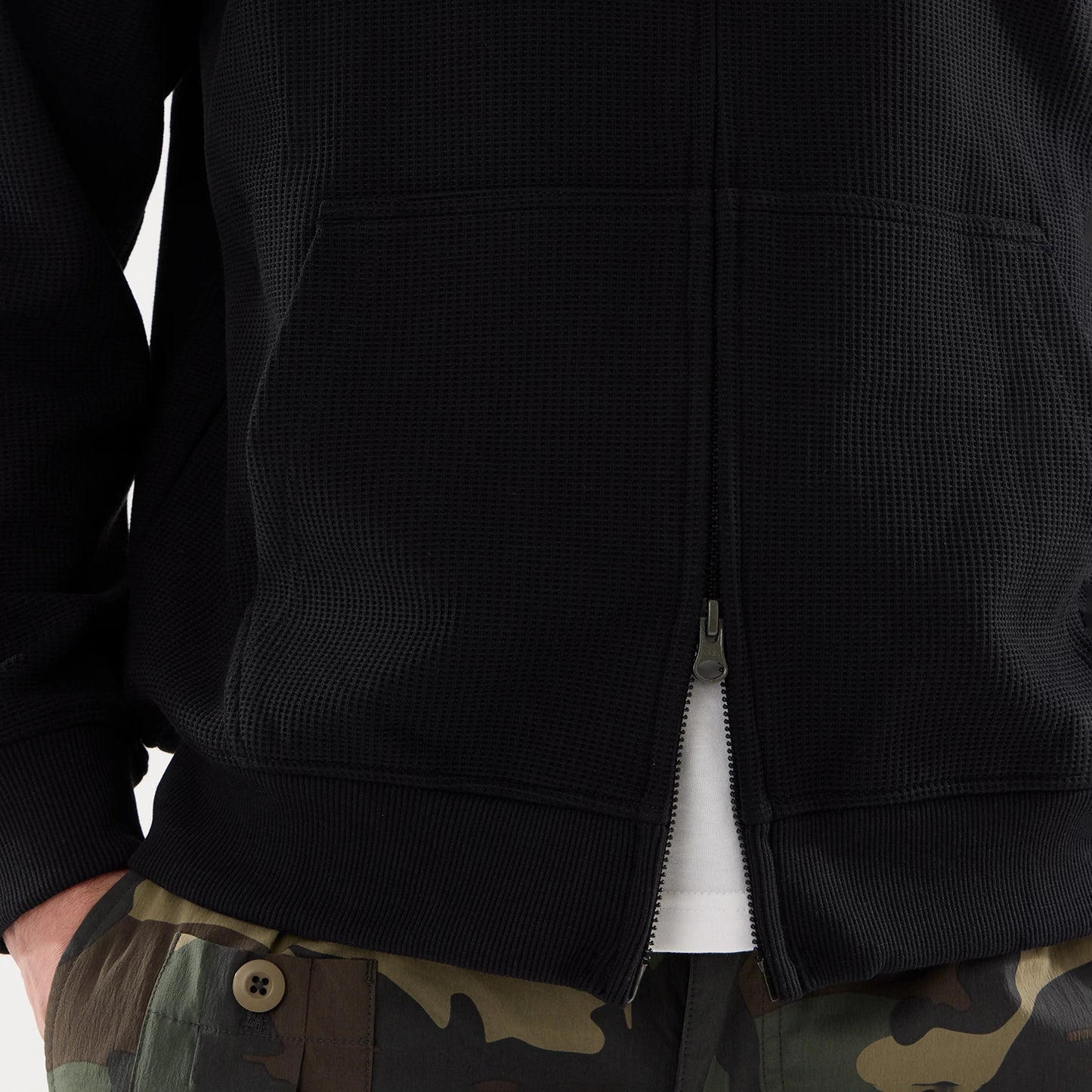 The model is wearing this New Era Waffle Full Zip Hoodie in black. 6