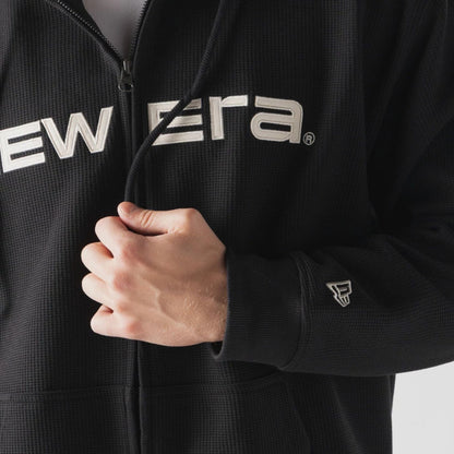 The model is wearing this New Era Waffle Full Zip Hoodie in black. 4