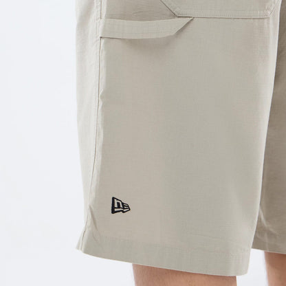 The model is wearing this New Era Canvas Bermuda Shorts in beige. 3