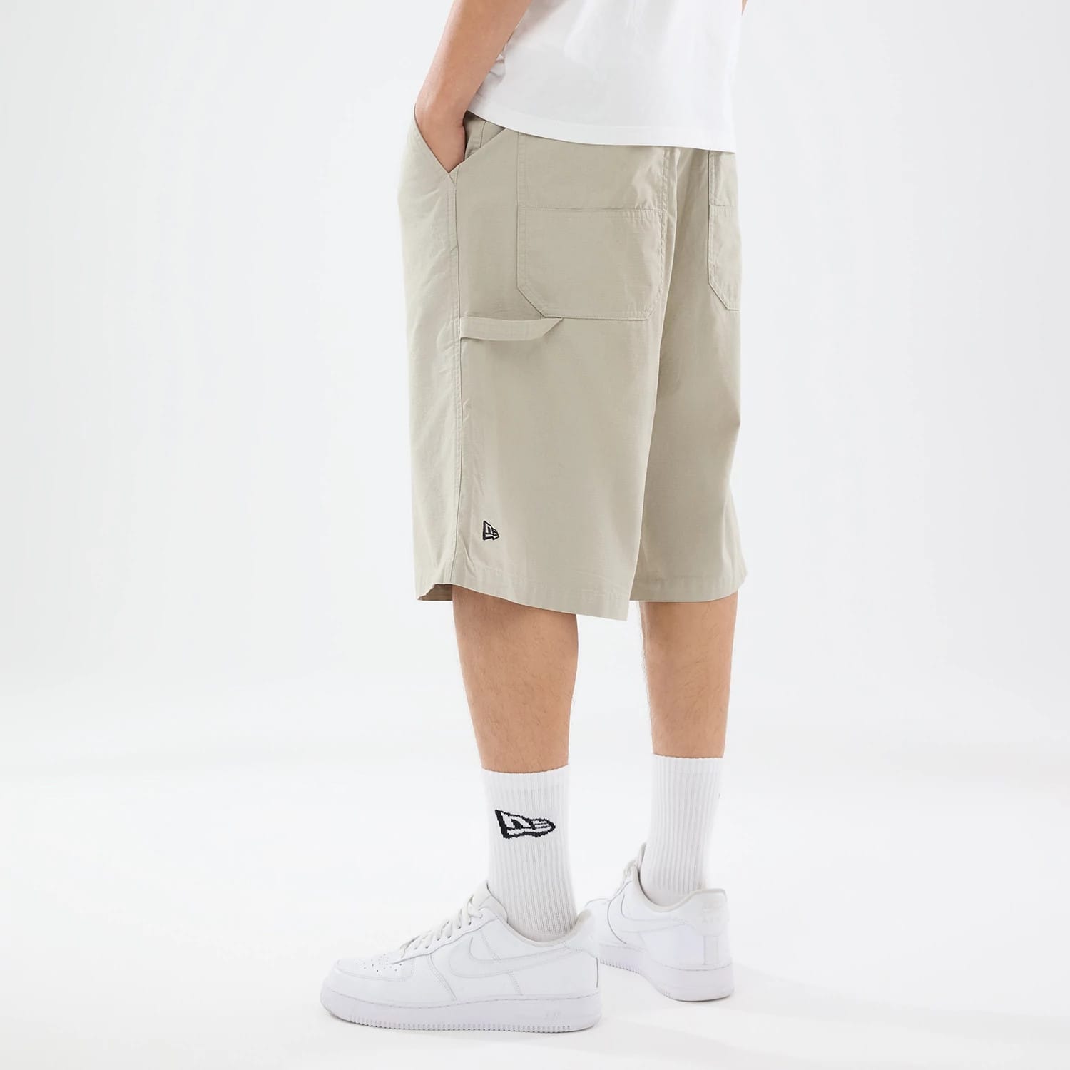 The model is wearing this New Era Canvas Bermuda Shorts in grey. 2