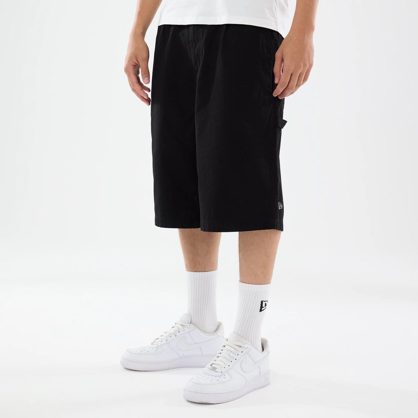 The model is wearing this New Era Canvas Bermuda Shorts in black. 1