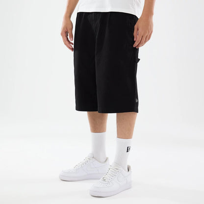 The model is wearing this New Era Canvas Bermuda Shorts in black. 1