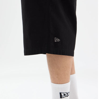 The model is wearing this New Era Canvas Bermuda Shorts in black. 3