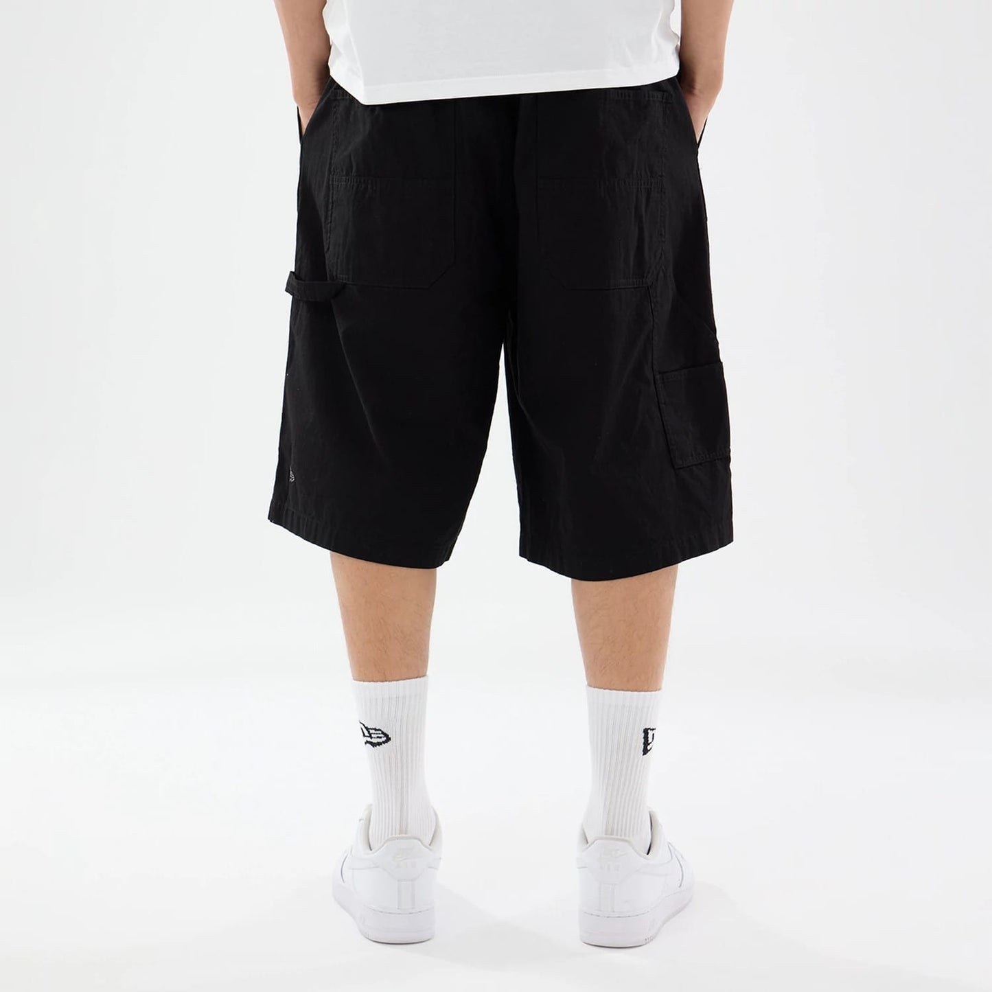 The model is wearing this New Era Canvas Bermuda Shorts in black. 2