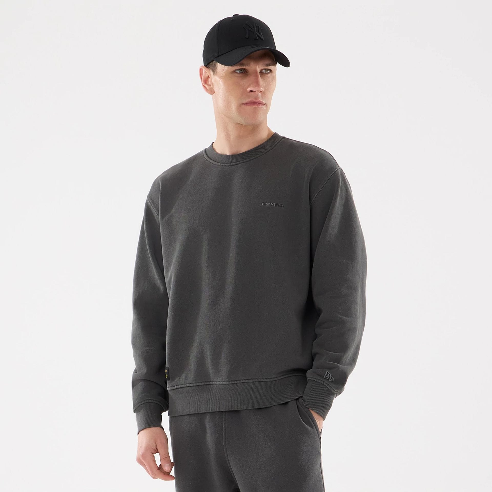 The model is wearing this New Era Originators Crew Neck Sweater in black. 1