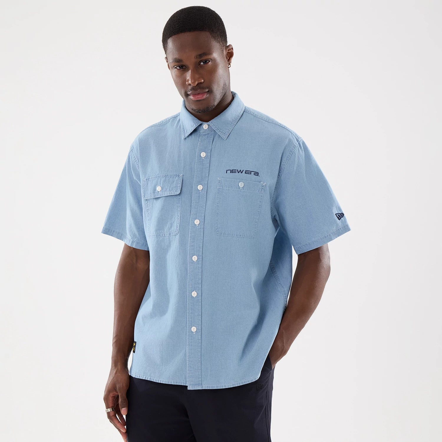 The model is wearing this New Era Originators Chambray Short Sleeve Shirt in bright blue. 1