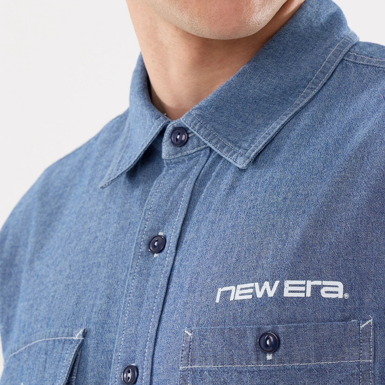 The model is wearing this New Era Originators Chambray Short Sleeve Shirt in dark blue. 4