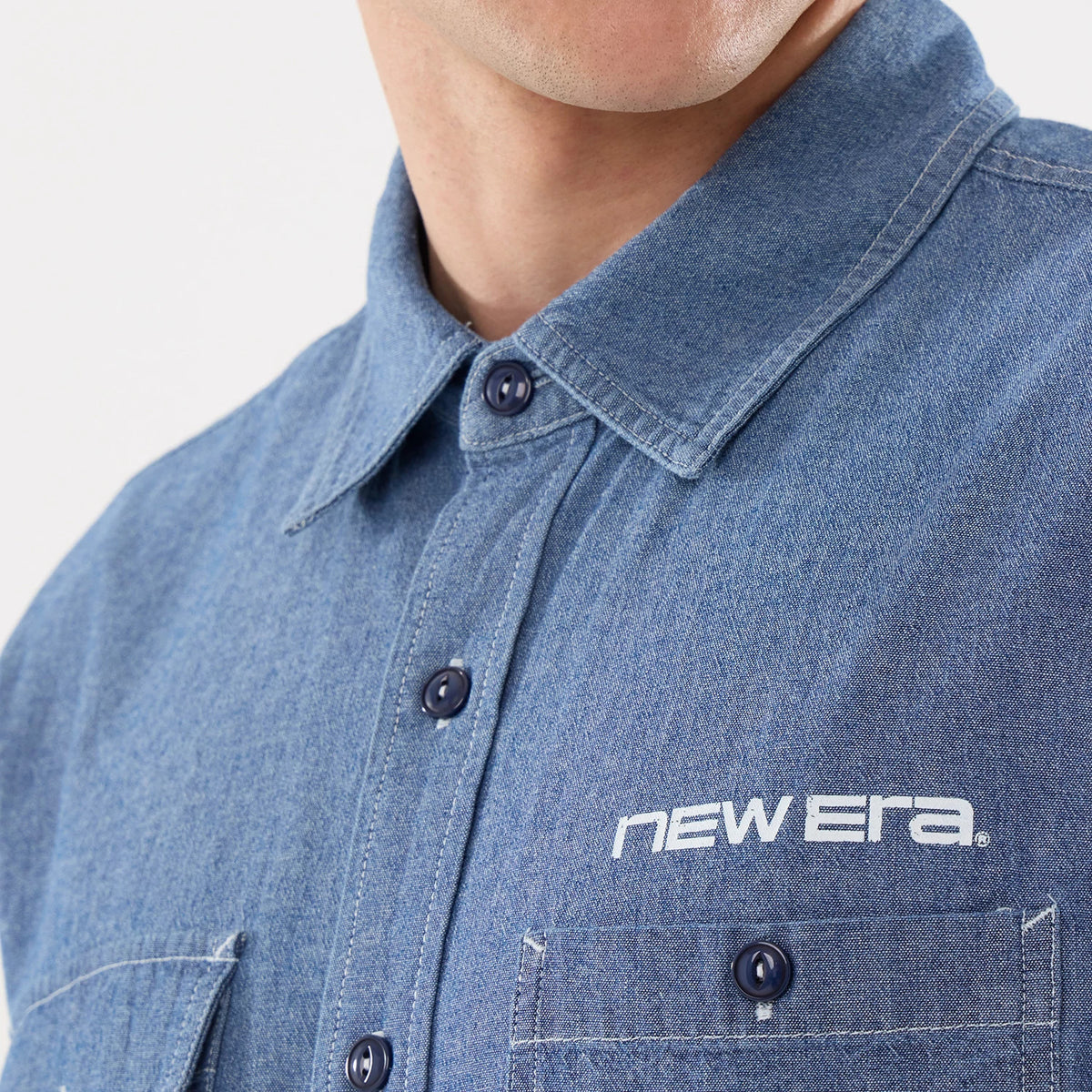The model is wearing this New Era Originators Chambray Short Sleeve Shirt in dark blue. 4
