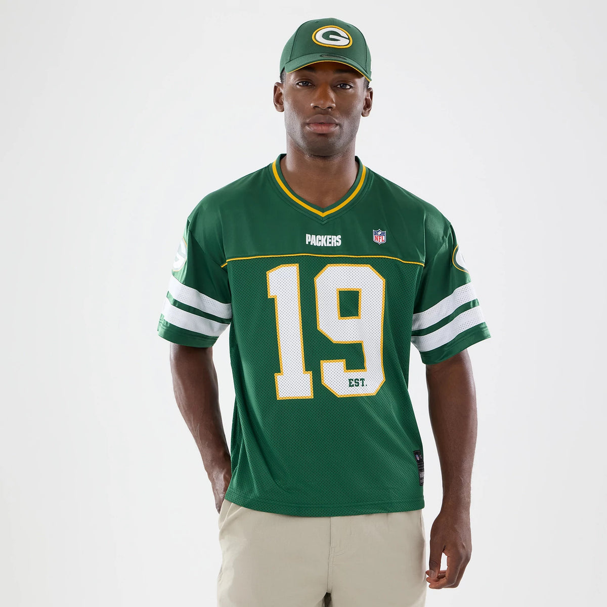 Green Bay Packers NFL Green Mesh Jersey, front view on a model with matching cap, showing white Packers lettering above the player number 19, green and white sleeve stripes, and the official NFL shield logo on the chest.