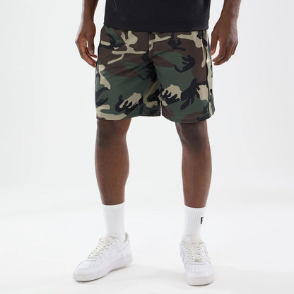 The model is wearing this New Era Bermuda Oversized Shorts in 6 Day Camo. 1