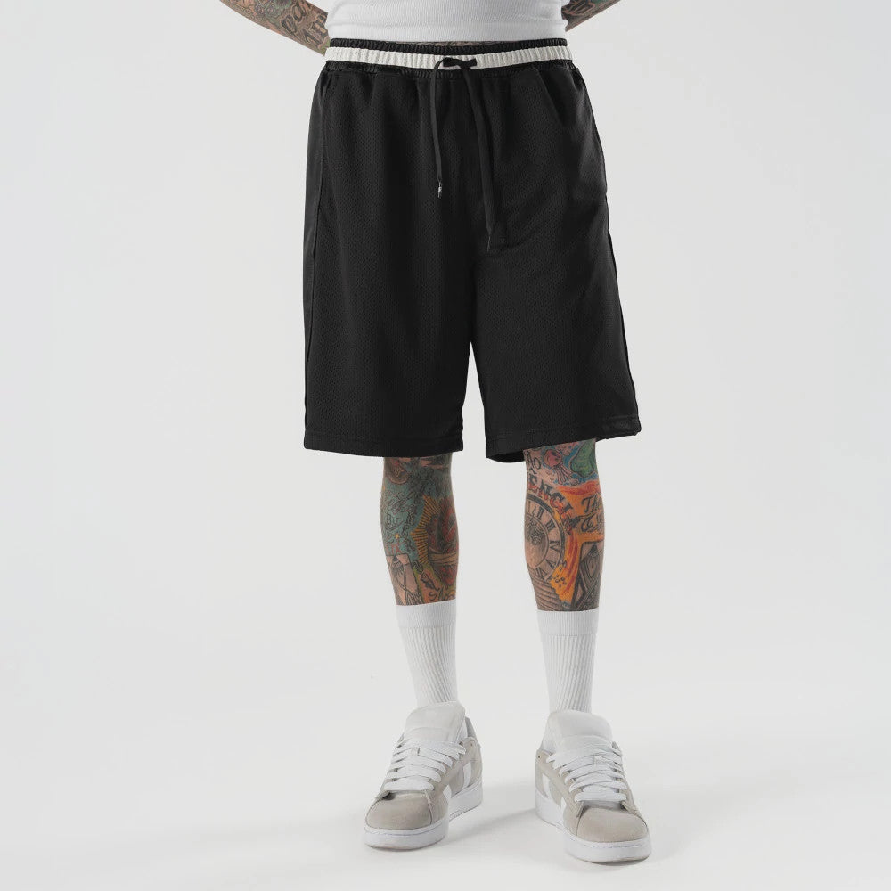 The model is wearing this New Era Bermuda Oversized Shorts in black. 1