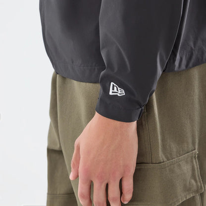 The model is wearing this New Era Windbreaker Jacket in black. 3