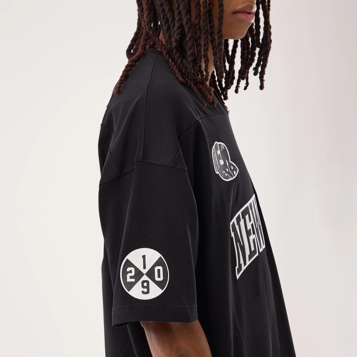 The model is wearing this New Era Fan Family Jersey in black. 6