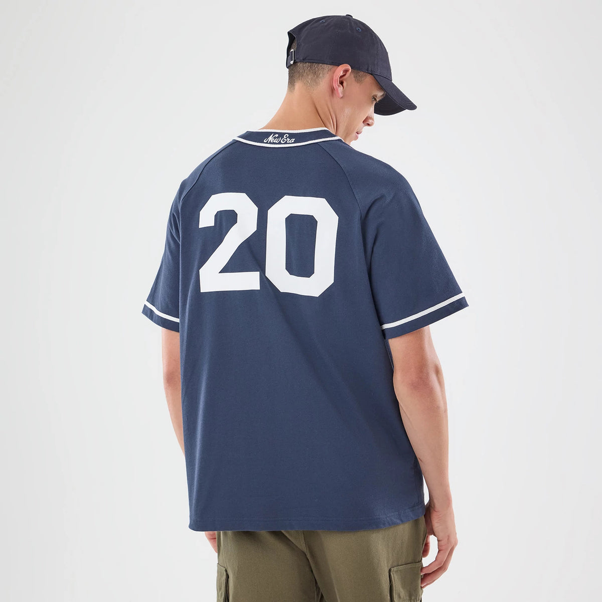 New Era New York Navy Jersey, back view on a model wearing a navy cap, showing the number 20 in white print across the upper back with New Era script embroidered at the base of the neck.