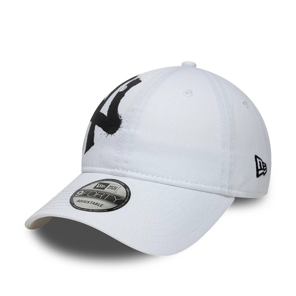 New York Yankees MLB Spray Paint White New Era 9FORTY Adjustable Cap, three-quarter view showing the black spray paint effect Yankees logo on the front panel, grey 9FORTY size sticker on the curved visor, and New Era flag logo on the left side.