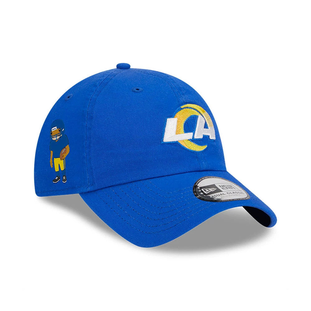 LA Rams NFL X Bad Bunny Bright Blue New Era Casual Classic Adjustable Cap, three-quarter view with a white and yellow LA logo embroidered on the front panel, a cartoon player on the left side, and a New Era sticker on the blue visor.