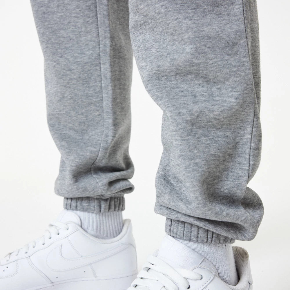 New York Yankees MLB Essential Grey Joggers, close-up view showing the textured grey fabric and elasticated cuffs, paired with white athletic shoes and white ribbed socks for a casual look.
