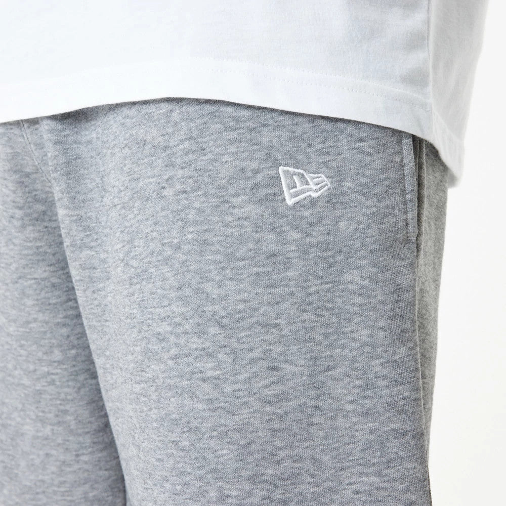 New York Yankees MLB Essential Grey Joggers, close-up showing the white embroidered New Era flag logo on the left thigh, with a portion of a white T-shirt visible at the waistline.