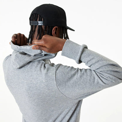 New Era Essential Grey Pullover Hoodie, on-model rear view showing the grey fabric with the hood being adjusted, long sleeves, and a black cap with an embossed New Era logo on the back.