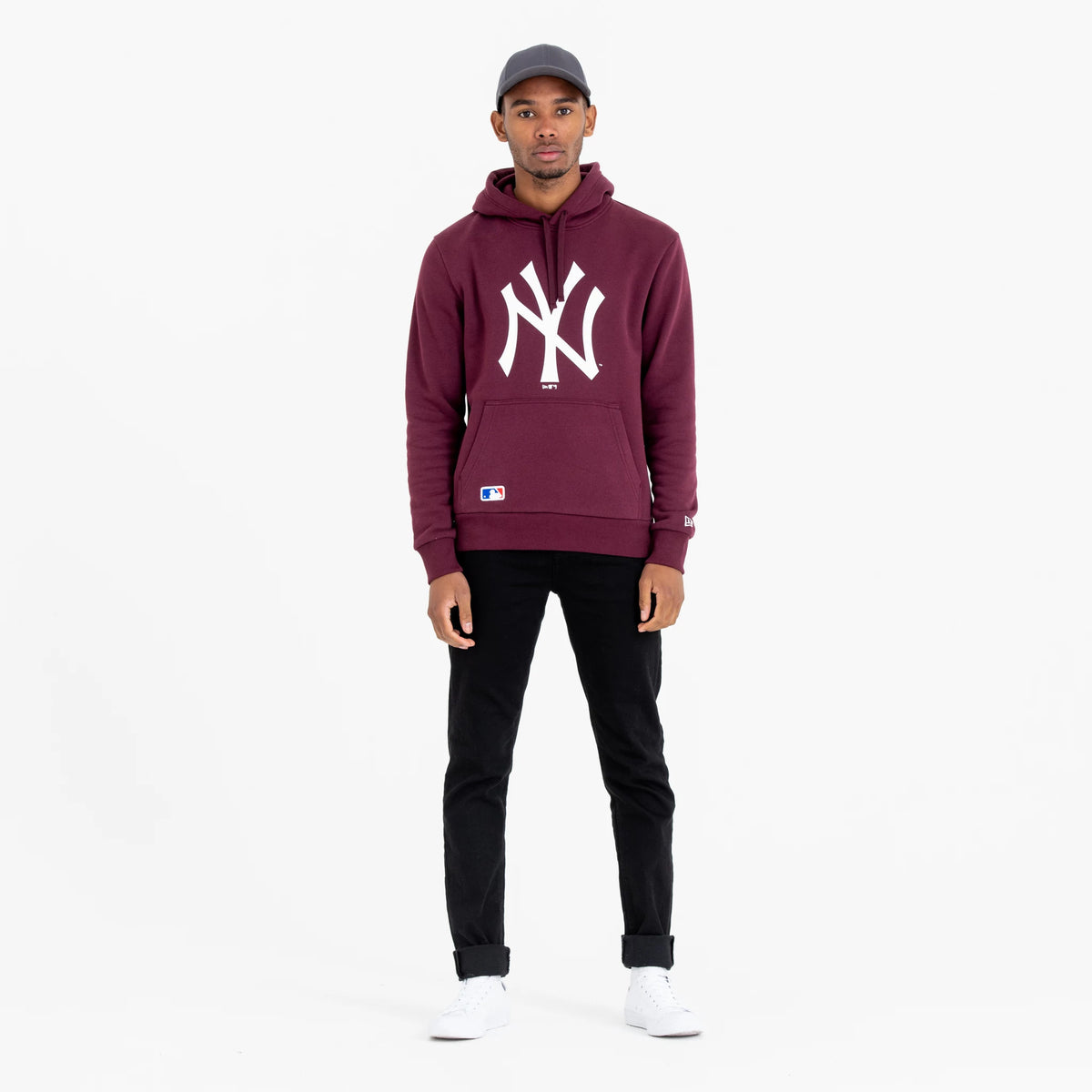 New York Yankees MLB Regular Dark Purple Pullover Hoodie, on-model view showing the white New York Yankees logo prominently centred on the chest, a small MLB patch near the hem, and a debossed New Era logo on the left sleeve.