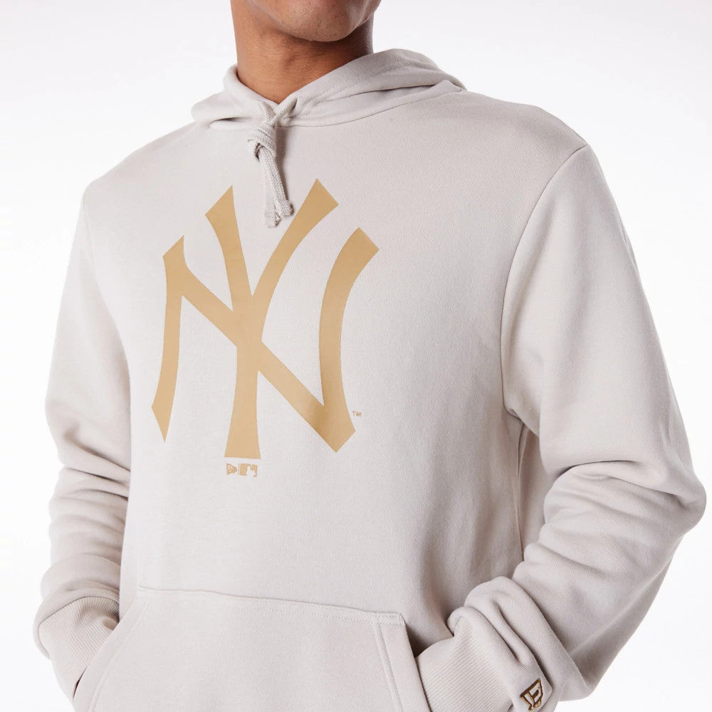 New York Yankees MLB Regular Light Beige Pullover Hoodie, front view showing a large gold NY logo printed on the chest, a drawstring hood at the top, and a debossed New Era logo on the left wrist.