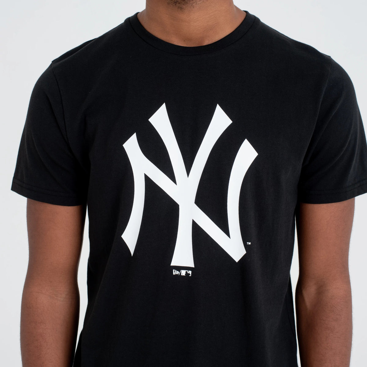 New Era New York Yankees MLB Regular Black T-Shirt, front view showing a large white New York Yankees logo centred on the chest of the black fabric, with short sleeves and a round neckline.