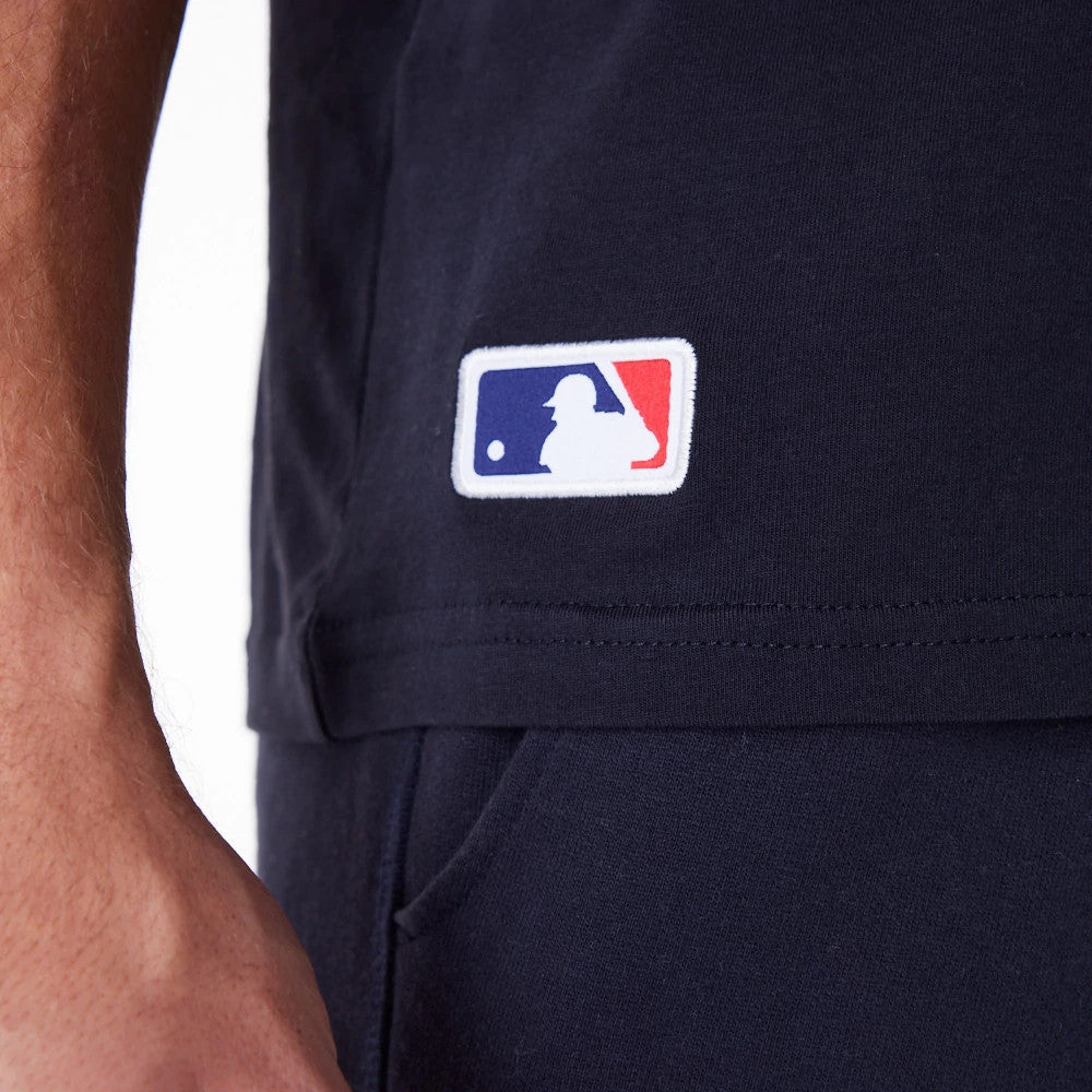New York Yankees MLB Regular Navy T-Shirt, side view showing a navy fabric with an embroidered white, red, and blue MLB logo positioned near the hem on the side above the waistband.