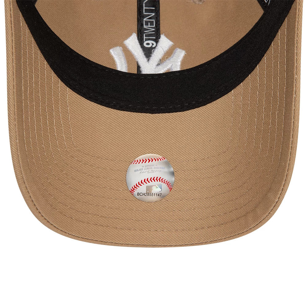 New York Yankees League Essential Light Beige New Era 9TWENTY Adjustable Cap, inside view showing black taping with 9TWENTY branding, white sweatband, and New York Yankees logo embroidered on tan undervisor with a holographic baseball sticker.