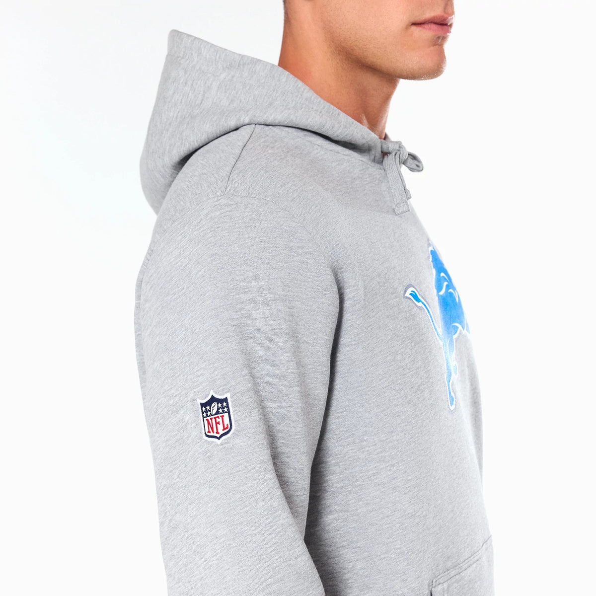 New Era Detroit Lions NFL Grey Pullover Hoodie, side view showing a grey hoodie with the embroidered Detroit Lions logo in blue on the chest and an embroidered NFL logo on the left sleeve.