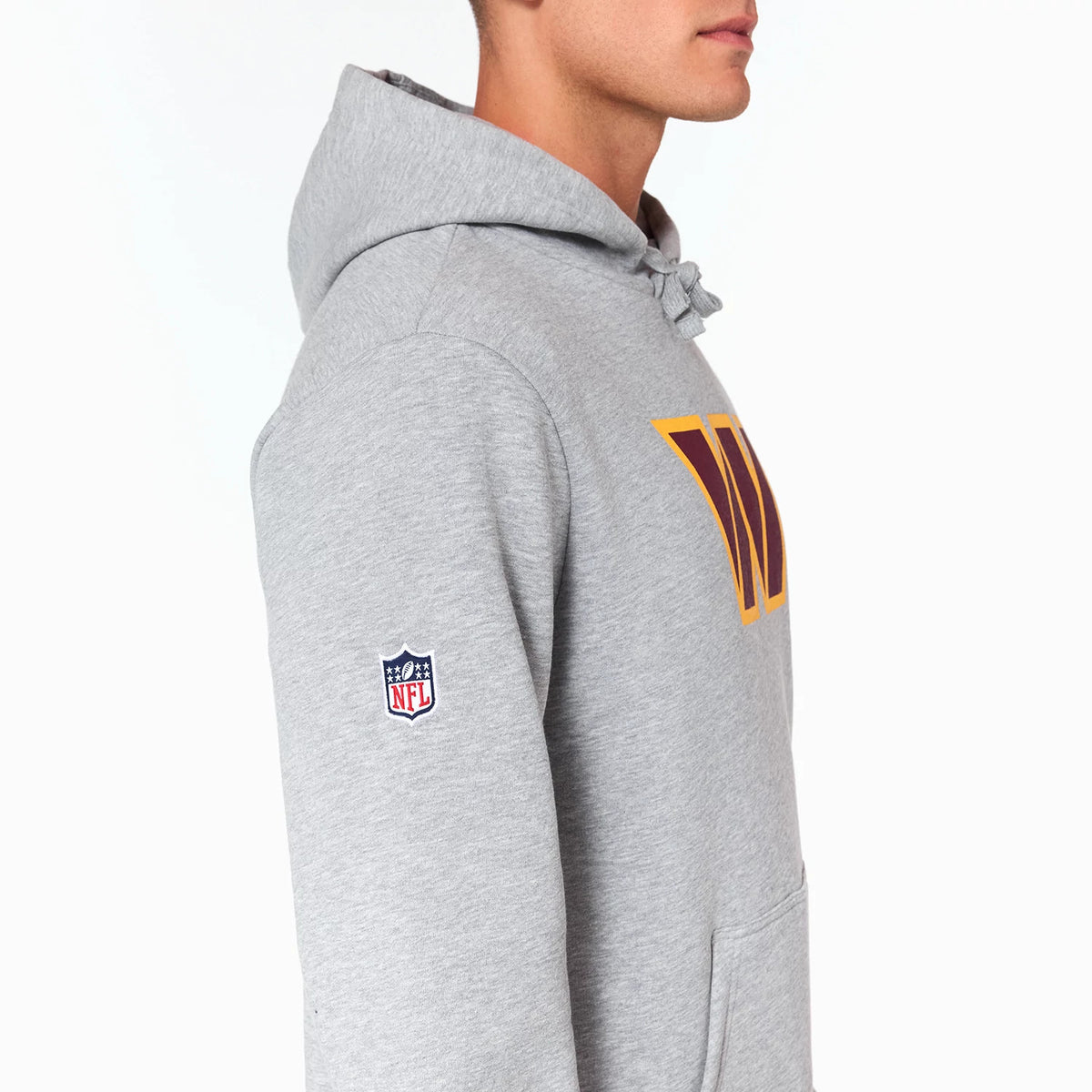 New Era Washington Commanders NFL Grey Pullover Hoodie, side view showing the grey fabric with a raised team logo on the chest, an embroidered NFL logo on the sleeve, and a hood with drawstrings.