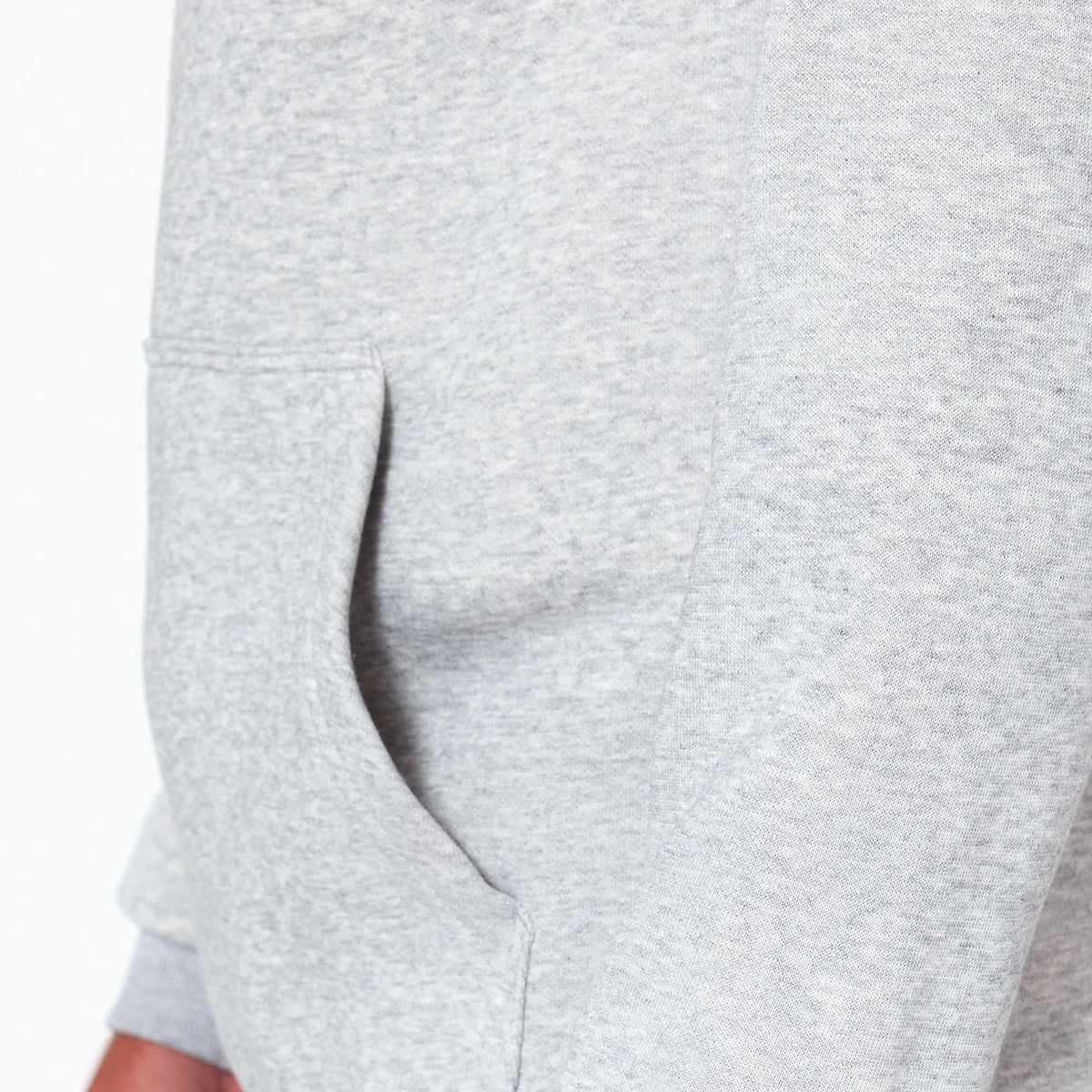 New Era Washington Wizards NBA Grey Pullover Hoodie, side view showing a plain light grey body with a kangaroo pocket opening on the left side waist and ribbed cuff peeking from the rolled sleeve.